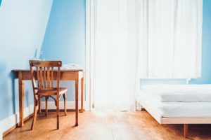 table and bed in a baby blue room
