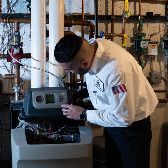 A technician in a white shirt is inspecting a gas furnace, demonstrating expertise in heating system maintenance.